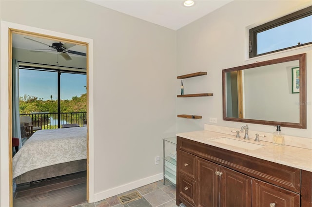 bathroom with vanity, stone finish floor, a ceiling fan, baseboards, and recessed lighting