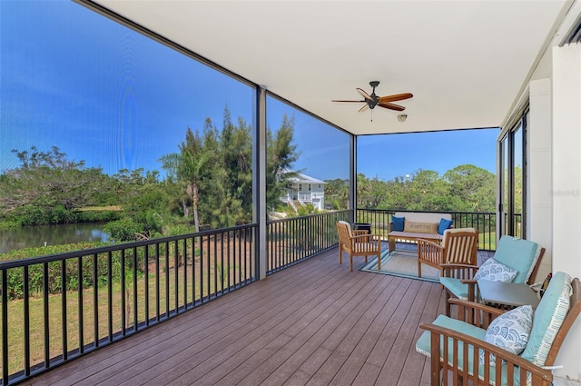 sunroom with a water view, ceiling fan, and outdoor lounge area