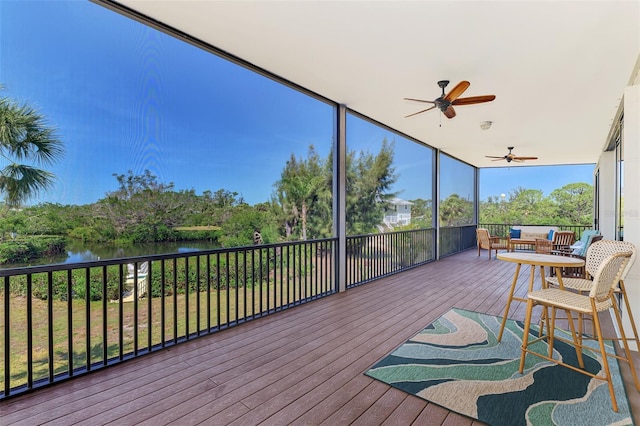 sunroom with a water view and a ceiling fan