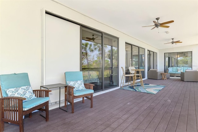 sunroom with plenty of natural light, a ceiling fan, and outdoor lounge area