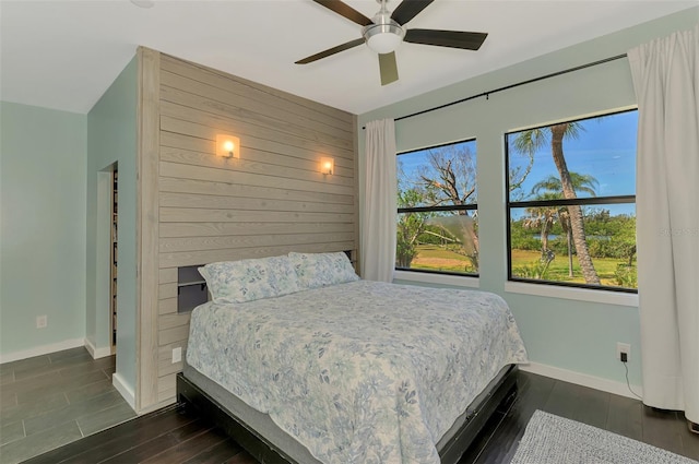 bedroom featuring baseboards, ceiling fan, and dark wood-type flooring