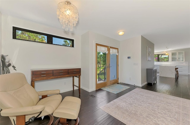 foyer entrance featuring baseboards, a chandelier, and hardwood / wood-style floors
