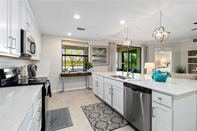 10805 Tarflower Dr Unit 101, Venice, FL 34293 - kitchen featuring appliances with stainless steel finishes, a sink, a chandelier, tasteful backsplash, and white cabinetry