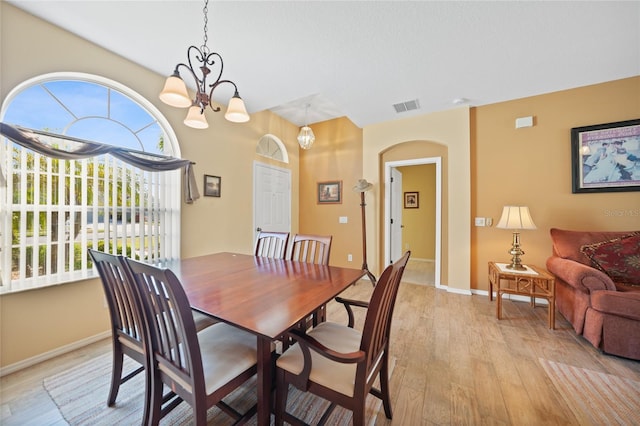 4004 Landor Ct, Venice, FL 34293 - dining room with light wood-type flooring, arched walkways, an inviting chandelier, baseboards, and visible vents
