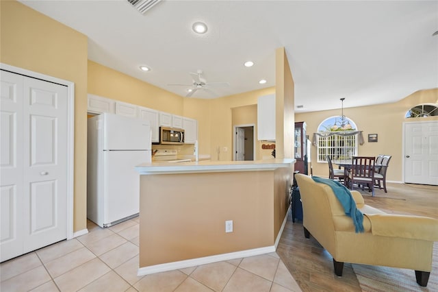 4004 Landor Ct, Venice, FL 34293 - kitchen with white cabinets, stainless steel microwave, stove, visible vents, and freestanding refrigerator