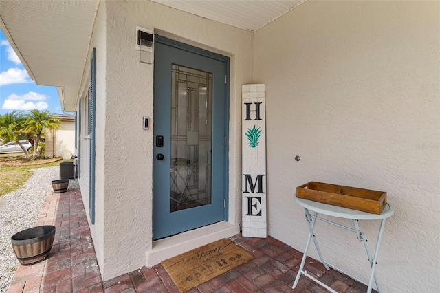 doorway to property featuring stucco siding