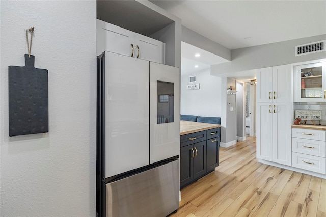 kitchen with smart refrigerator, white cabinetry, butcher block countertops, and glass insert cabinets