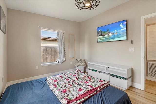 bedroom featuring baseboards, visible vents, and light wood-style flooring