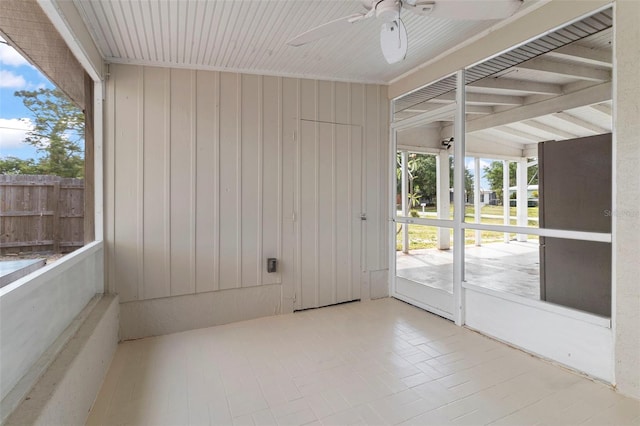 unfurnished sunroom featuring ceiling fan and plenty of natural light