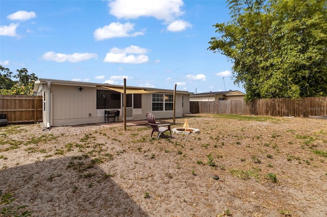 back of property featuring a fire pit, a patio area, and a fenced backyard