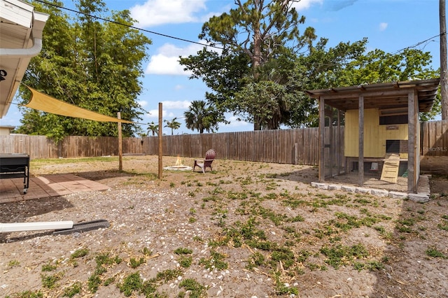 view of yard with an outdoor structure, a fenced backyard, and exterior structure