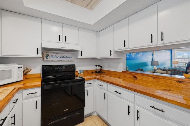 1531 Placida Rd Unit 201, Englewood, FL 34223 - kitchen with black range with electric cooktop, white microwave, under cabinet range hood, wooden counters, and light tile patterned floors