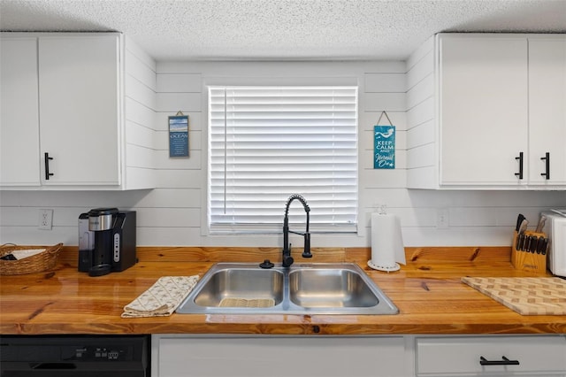 1531 Placida Rd Unit 201, Englewood, FL 34223 - kitchen with white cabinets, black dishwasher, a sink, wood counters, and a textured ceiling