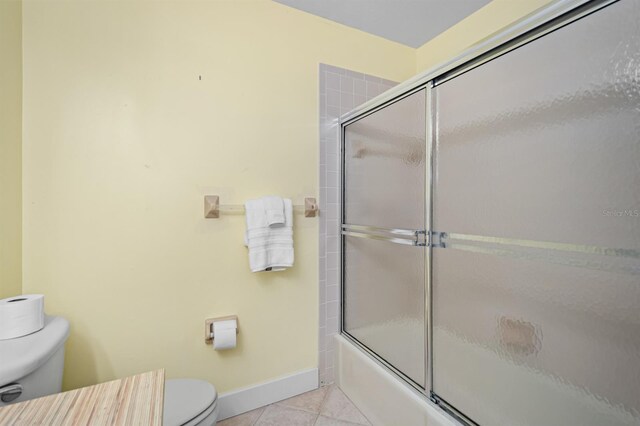 full bath with toilet, baseboards, enclosed tub / shower combo, and tile patterned floors