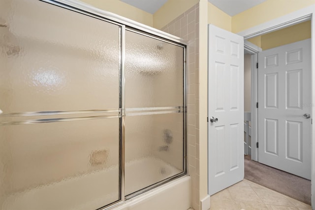 full bath with shower / bath combination with glass door and tile patterned floors