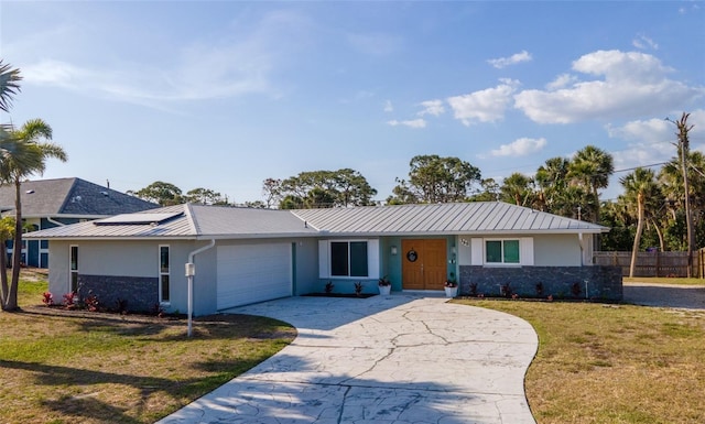 ranch-style home featuring stucco siding, a front yard, metal roof, and an attached garage