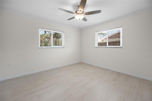 empty room with baseboards, a ceiling fan, ornamental molding, and a wealth of natural light
