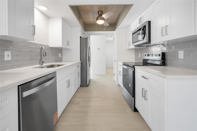 kitchen with a ceiling fan, a sink, white cabinetry, and stainless steel appliances