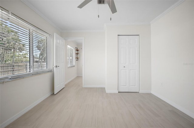 unfurnished bedroom featuring crown molding, a closet, a ceiling fan, and baseboards