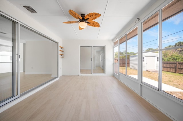 unfurnished sunroom featuring visible vents and a ceiling fan