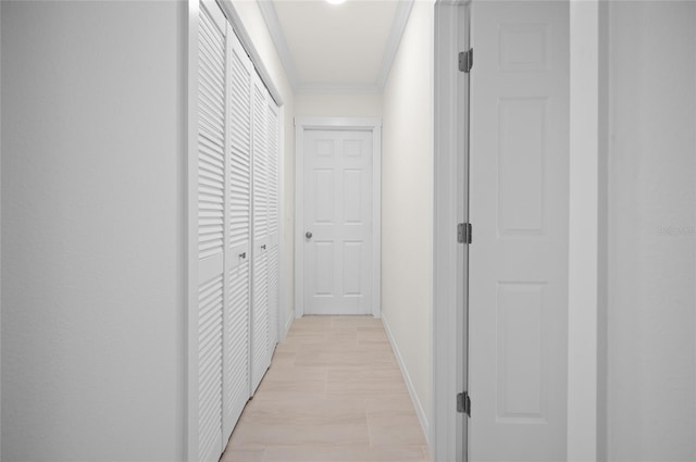 corridor with ornamental molding and baseboards