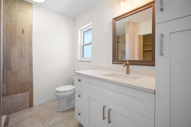 bathroom featuring vanity, toilet, tile patterned flooring, and tiled shower