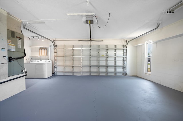 garage with a garage door opener and separate washer and dryer