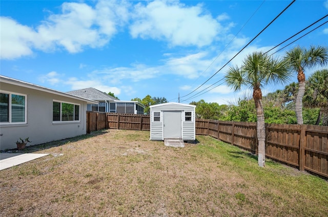 view of yard with a storage unit, an outdoor structure, and a fenced backyard