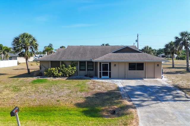 single story home with roof with shingles, driveway, a front yard, and stucco siding