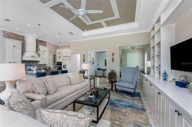 living area with ceiling fan, a tray ceiling, crown molding, and recessed lighting