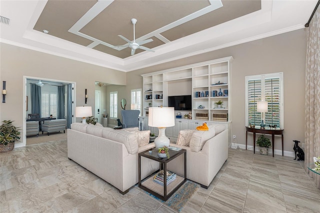 living area featuring a ceiling fan, a raised ceiling, crown molding, a towering ceiling, and baseboards