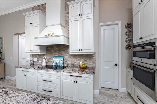 kitchen with premium range hood, black electric stovetop, double oven, light stone counters, and crown molding