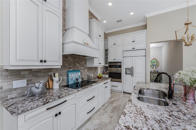 kitchen with black electric cooktop, a sink, custom exhaust hood, crown molding, and white cabinets