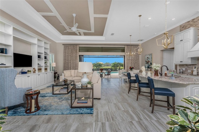 living room with a chandelier, ceiling fan, and ornamental molding