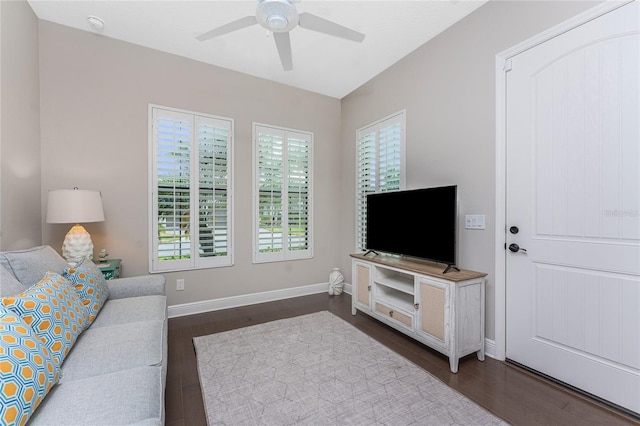 living room with ceiling fan, dark wood finished floors, and baseboards