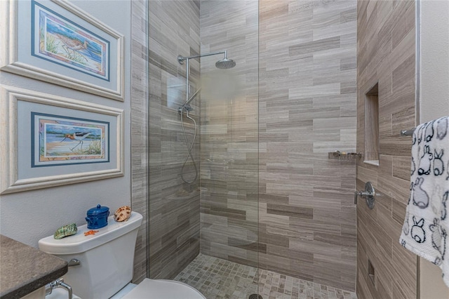 full bath with tiled shower, toilet, and vanity