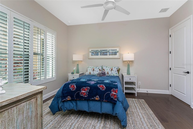 bedroom with multiple windows, wood finished floors, baseboards, and a ceiling fan