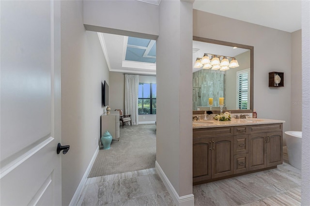 bathroom with a skylight, baseboards, double vanity, crown molding, and marble finish flooring