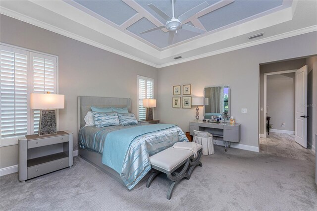 bedroom with a raised ceiling, ornamental molding, carpet floors, baseboards, and a ceiling fan