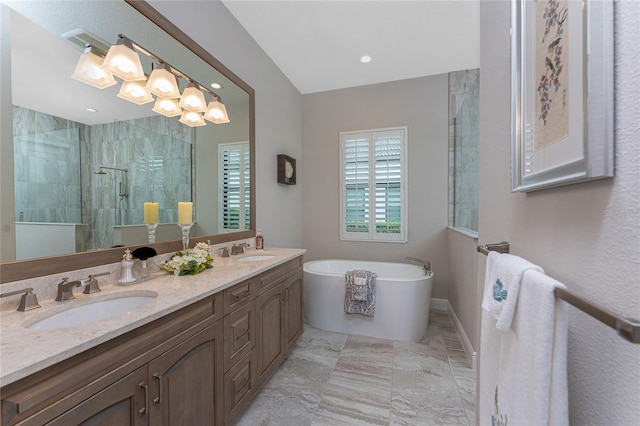 bathroom with tiled shower, a freestanding tub, double vanity, marble look tile flooring, and recessed lighting