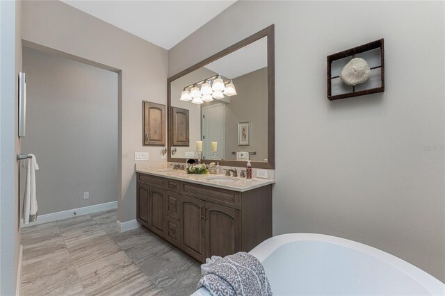 full bathroom featuring a chandelier, a soaking tub, and double vanity