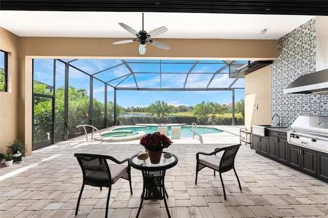view of swimming pool with exterior kitchen, a ceiling fan, a grill, a patio area, and a sink