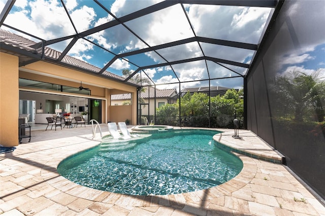 view of swimming pool with a patio area, a ceiling fan, a pool with connected hot tub, and a lanai