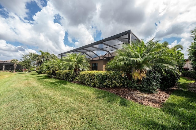 view of grassy yard featuring a lanai