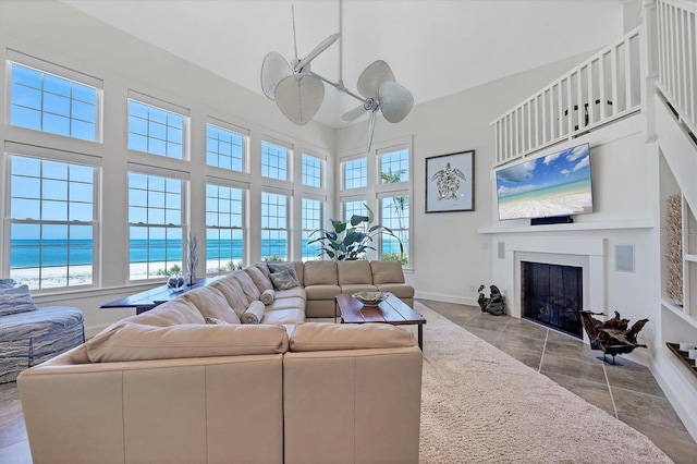 6890 Palm Island Dr, Placida, FL 33946 - living area featuring baseboards, a towering ceiling, a fireplace with flush hearth, and a healthy amount of sunlight