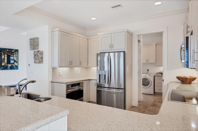 6890 Palm Island Dr, Placida, FL 33946 - kitchen with crown molding, a sink, appliances with stainless steel finishes, and washer / clothes dryer