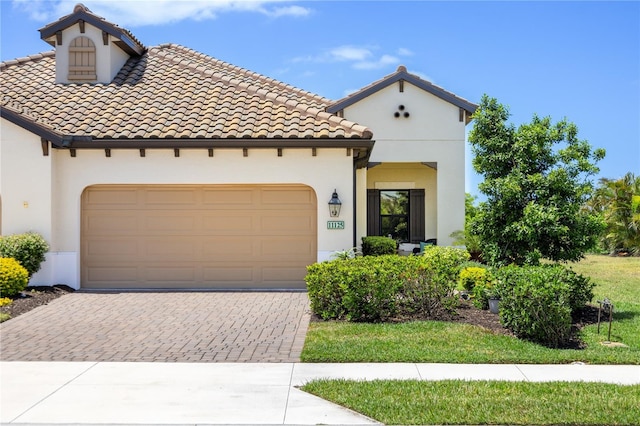 11125 Mcdermott Ct, Englewood, FL 34223 - mediterranean / spanish-style house featuring a garage, stucco siding, and driveway