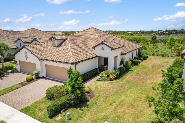 11125 Mcdermott Ct, Englewood, FL 34223 - view of front of house with a tile roof, a front yard, a garage, decorative driveway, and stucco siding