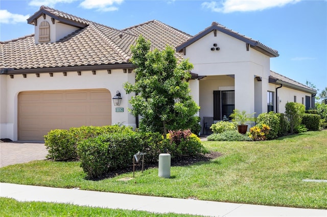 11125 Mcdermott Ct, Englewood, FL 34223 - mediterranean / spanish-style house with a tiled roof, driveway, a front lawn, an attached garage, and stucco siding