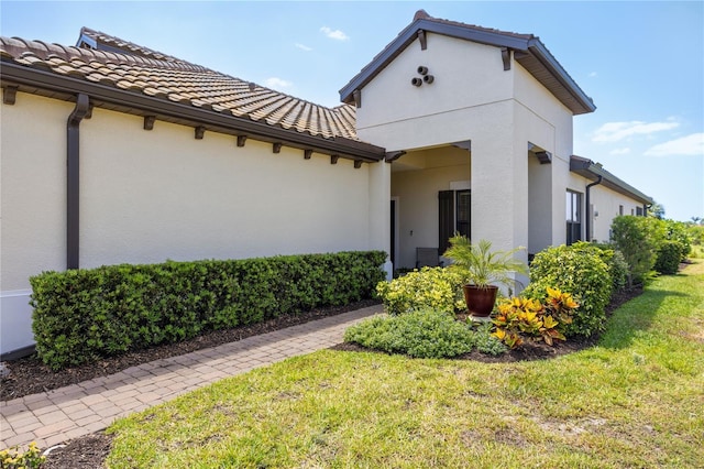 11125 Mcdermott Ct, Englewood, FL 34223 - exterior space with a lawn, stucco siding, and a tiled roof